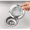 A hand holding a metal sink strainer with fine mesh, positioned above a kitchen sink drain. The drain is stainless steel, with a visible opening for debris. | MySmartiee