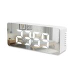 Digital alarm clock with mirrored surface showing the time as 23:59. The reflection displays a cozy bedroom with a bed, nightstand, and hanging lights. The clock has a white rectangular design and ventilated sides. | MySmartiee